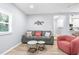 Open-concept living room with a comfortable gray couch, side tables, and seamless access to the adjacent kitchen area at 5421 Gay St, Weeki Wachee, FL 34607