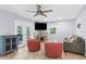 Cozy living room with a fireplace, ceiling fan, comfortable seating, and abundant natural light at 5421 Gay St, Weeki Wachee, FL 34607