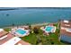 Aerial view of complex with two swimming pools, palm trees, lush green lawns and waterfront at 6290 Bahia Del Mar Cir # 12, St Petersburg, FL 33715