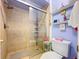 Bathroom featuring a shower with tan tiling, glass door, and open shelving for toiletries at 6290 Bahia Del Mar Cir # 12, St Petersburg, FL 33715