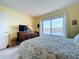 Bedroom with a view features a patterned bedspread, dresser, and large window overlooking the water at 6290 Bahia Del Mar Cir # 12, St Petersburg, FL 33715