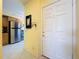 Inviting entryway features a white door and a glimpse into the kitchen with stainless steel appliances and neutral tiling at 6290 Bahia Del Mar Cir # 12, St Petersburg, FL 33715