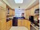 Eat-in kitchen boasts stone counters, wood cabinetry, and a view to the water and dining area at 6290 Bahia Del Mar Cir # 12, St Petersburg, FL 33715