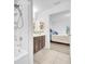 Bright bathroom featuring a shower, vanity, and neutral tile flooring at 7099 Crested Orchid Dr, Brooksville, FL 34602