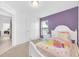 Bright bedroom with carpet flooring, neutral and purple paint, and a nice sized window at 7099 Crested Orchid Dr, Brooksville, FL 34602