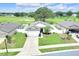 Well-maintained single-story home boasts a manicured lawn, mature tree, and inviting curb appeal at 7099 Crested Orchid Dr, Brooksville, FL 34602