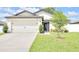 Well-maintained home featuring a two-car garage, manicured lawn, and fresh landscaping at 7099 Crested Orchid Dr, Brooksville, FL 34602
