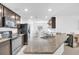 Modern kitchen featuring granite countertops, stainless steel appliances, and dark wood cabinetry at 7099 Crested Orchid Dr, Brooksville, FL 34602