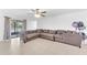 Spacious living room featuring a large sectional sofa, tile flooring, and lots of natural light at 7099 Crested Orchid Dr, Brooksville, FL 34602