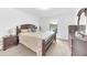 Bright main bedroom features a large bed, neutral carpet, and a window with a view of the outdoors at 7099 Crested Orchid Dr, Brooksville, FL 34602