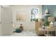 Charming Bedroom with a cozy chair, wooden crib, soft blue accents, and natural light from a large window at 7537 E 116Th St, Palmetto, FL 34221