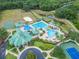 Stunning aerial view of the community pool, clubhouse, and recreational facilities with lush landscaping and walking trails at 8132 Stone Path Way, Tampa, FL 33647