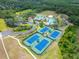Aerial view shows the clubhouse with tennis and sand courts along with the neighborhood pool at 8132 Stone Path Way, Tampa, FL 33647