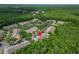 Aerial view shows townhome buildings in a community, surrounded by a pond and lush trees at 8132 Stone Path Way, Tampa, FL 33647