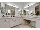 Bright bathroom featuring dual sinks, quartz counters, a vanity area with large mirrors at 8132 Stone Path Way, Tampa, FL 33647