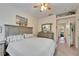 Bright bedroom features a neutral color palette, ceiling fan, and doorway leading into another room at 8132 Stone Path Way, Tampa, FL 33647