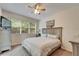 Comfortable bedroom featuring a ceiling fan, large window, and soft carpeting at 8132 Stone Path Way, Tampa, FL 33647
