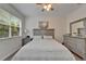 Bright bedroom features a neutral color palette, large window, ceiling fan and decorative furnishings at 8132 Stone Path Way, Tampa, FL 33647