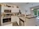 Well-lit kitchen with stainless steel appliances, granite countertops and white cabinetry at 8132 Stone Path Way, Tampa, FL 33647
