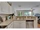 Bright kitchen features granite countertops, white cabinets, and stainless steel dishwasher at 8132 Stone Path Way, Tampa, FL 33647