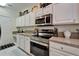 Modern kitchen features white cabinets, updated appliances and beautiful countertops at 8132 Stone Path Way, Tampa, FL 33647