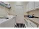 Well-equipped laundry room featuring a washer, dryer, storage cabinets, and a workspace area at 8132 Stone Path Way, Tampa, FL 33647