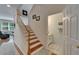 Staircase with hardwood stairs, white risers, and adjacent half bath at 8132 Stone Path Way, Tampa, FL 33647