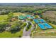 High-angle shot of community amenities, featuring pool, tennis courts, and lush greenery, ideal for leisure at 8208 Pinewood Run Ct, Tampa, FL 33647