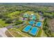 Overhead view of a community center with pools, tennis courts, and well-manicured landscaping at 8208 Pinewood Run Ct, Tampa, FL 33647
