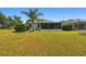 Large grassy backyard with screened-in lanai and paver patio at 8208 Pinewood Run Ct, Tampa, FL 33647