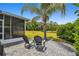 Paver patio features two chairs, lawn, and a picturesque view of the backyard at 8208 Pinewood Run Ct, Tampa, FL 33647