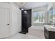 This modern bathroom features a soaking tub, dark accent wall, and tiled floors at 8208 Pinewood Run Ct, Tampa, FL 33647