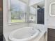 This bathroom has a soaking tub with a large window offering views of the neighborhood at 8208 Pinewood Run Ct, Tampa, FL 33647