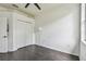 Clean, bright bedroom with dark hardwood floors, a ceiling fan, closet, and a modern floor lamp at 8208 Pinewood Run Ct, Tampa, FL 33647