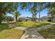Spacious home exterior with a well-maintained lawn, mature trees, and a charming sidewalk at 8208 Pinewood Run Ct, Tampa, FL 33647