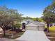 Beautiful home with a three-car garage, lush landscaping, and a basketball hoop at 8208 Pinewood Run Ct, Tampa, FL 33647