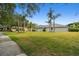 Well-maintained lawn and mature palm trees enhance the curb appeal of this home at 8208 Pinewood Run Ct, Tampa, FL 33647