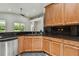 Bright kitchen with stainless steel dishwasher, black granite counters, and wood cabinetry at 8208 Pinewood Run Ct, Tampa, FL 33647