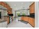 Spacious kitchen with stainless appliances, wood cabinetry, black granite counters, and recessed lights at 8208 Pinewood Run Ct, Tampa, FL 33647