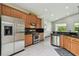 Well-lit kitchen with stainless steel appliances, black granite countertops, and wood cabinets at 8208 Pinewood Run Ct, Tampa, FL 33647