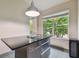 Modern kitchen island with sleek countertops, stainless steel drawers, and a view of lush tropical landscaping at 8208 Pinewood Run Ct, Tampa, FL 33647
