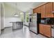 Kitchen featuring a stainless steel island, stainless appliances, wood cabinets, and granite counters at 8208 Pinewood Run Ct, Tampa, FL 33647