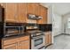 Kitchen with stainless steel range hood and stove, microwave, granite counters, and wood cabinets at 8208 Pinewood Run Ct, Tampa, FL 33647