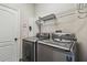 Efficient laundry room featuring modern Samsung washer and dryer, shelving and a crisp white door at 8208 Pinewood Run Ct, Tampa, FL 33647