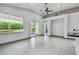 Open concept living space with grey tile flooring, large windows, and sliding door access at 8208 Pinewood Run Ct, Tampa, FL 33647