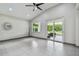 Open-concept living space with neutral tile flooring and a sliding door to the lanai at 8208 Pinewood Run Ct, Tampa, FL 33647