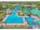 Aerial view of the community pool featuring lap lanes, a splash pad, lounge chairs, and lush landscaping at 8208 Pinewood Run Ct, Tampa, FL 33647