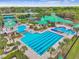 Community pool aerial view featuring a splash pad, lap lanes, a gazebo, lush landscaping, and lounge seating at 8208 Pinewood Run Ct, Tampa, FL 33647