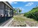 Backyard featuring a screened porch, green space, and mature trees at 9023 Sienna Moss Ln, Riverview, FL 33578