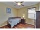 Cozy bedroom with hardwood floors, ceiling fan, and a comfortable bed at 9023 Sienna Moss Ln, Riverview, FL 33578